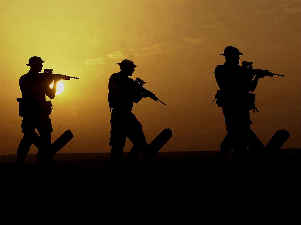 Pennant awarded Ministry of Defence FATS 4 accreditation 1 Three people with guns walking in as the sun is setting