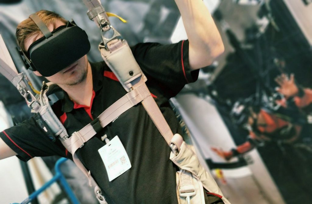 Someone wearing a VR headset and in a parachute harness