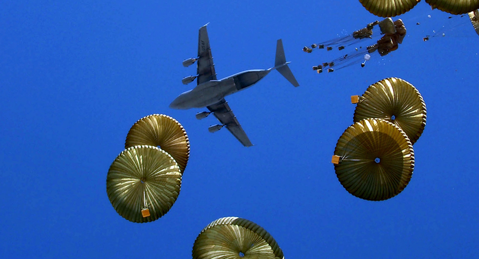 Teaming agreement signed with Capewell Aerial Systems LLC 8 A stock image of a plane dropping numerous parachute parcels. The sky is blue.