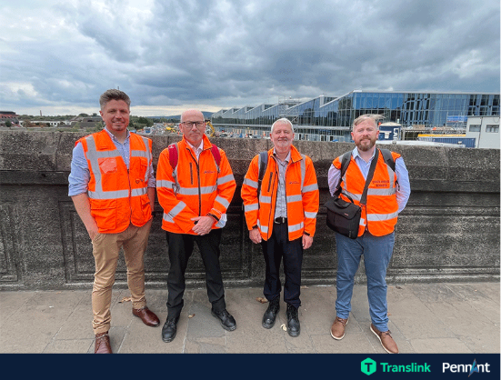 A photograph of two members of the Pennant team and two members of the Translink team, meeting in Belfast.