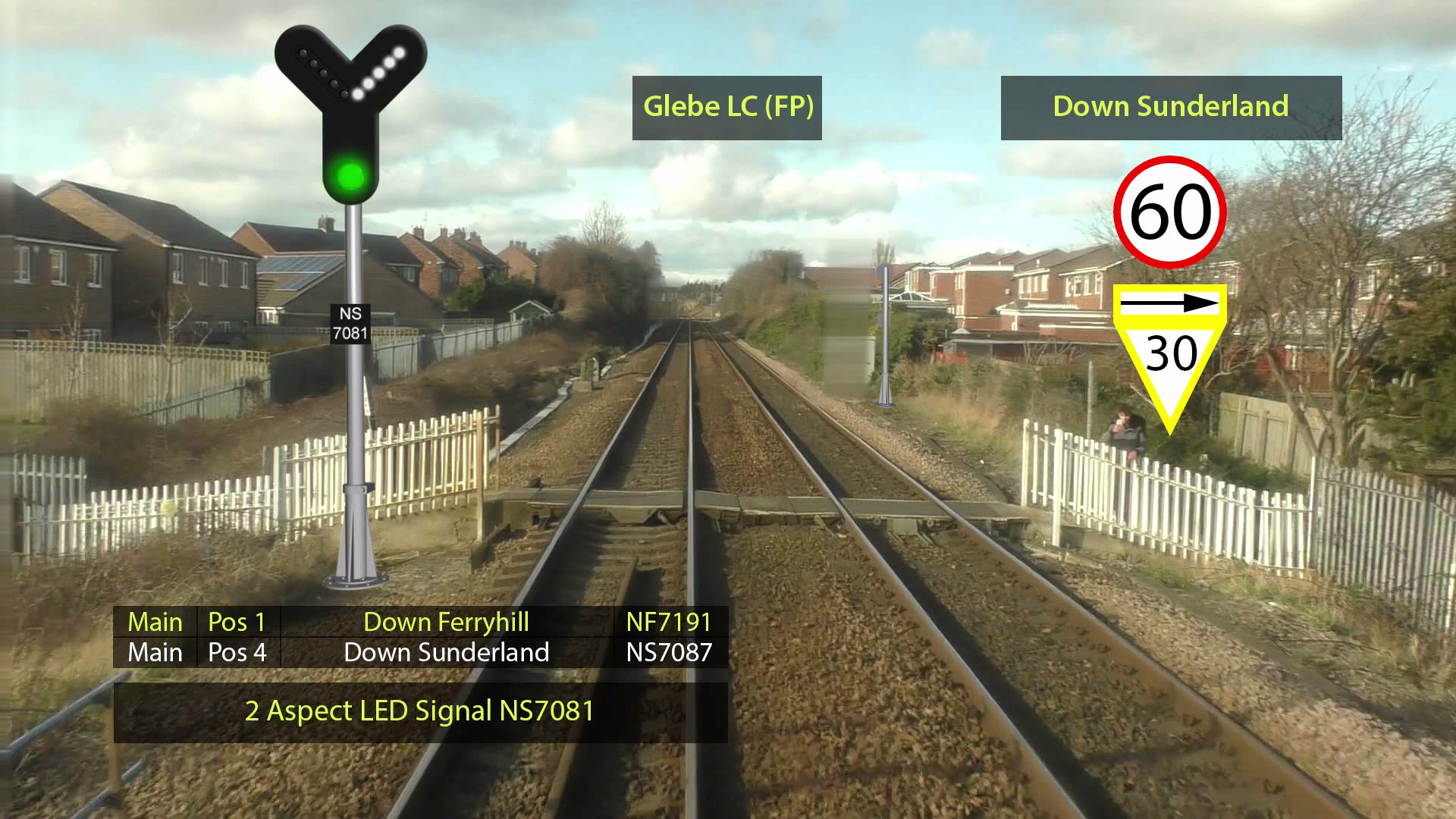 Durham Coast Driver Training 1b A railway crossing with metal gates, signal lights, and a pedestrian walkway, surrounded by greenery under a partly cloudy sky.