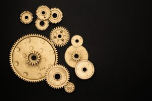A black background of gold cogs. These are different sizes and and some are overplayed.