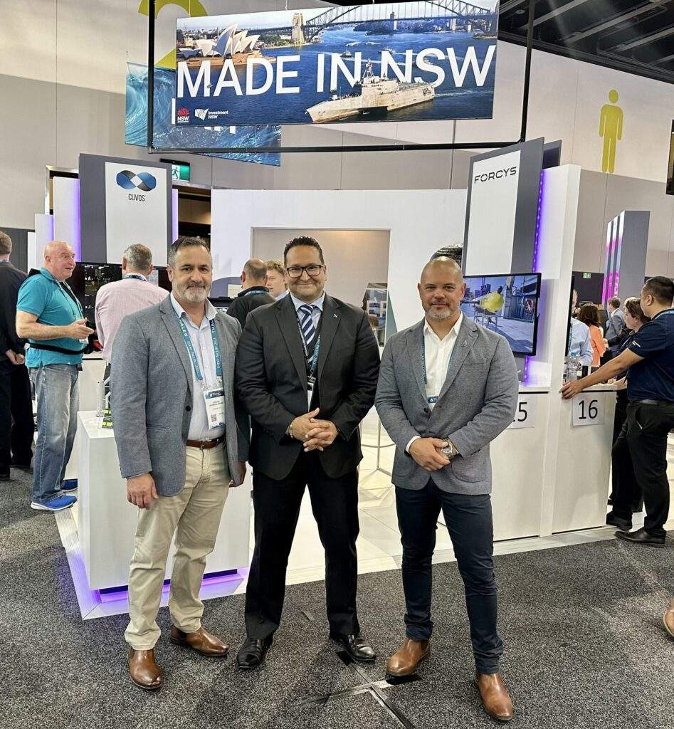 Another successful Indo Pacific Expo for the Pennant Team 7 A collage of images from a trade show featuring people with faces blurred standing near various exhibits including ‘MADE IN NSW’, and military equipment displays by EOS and RADIO MARINE